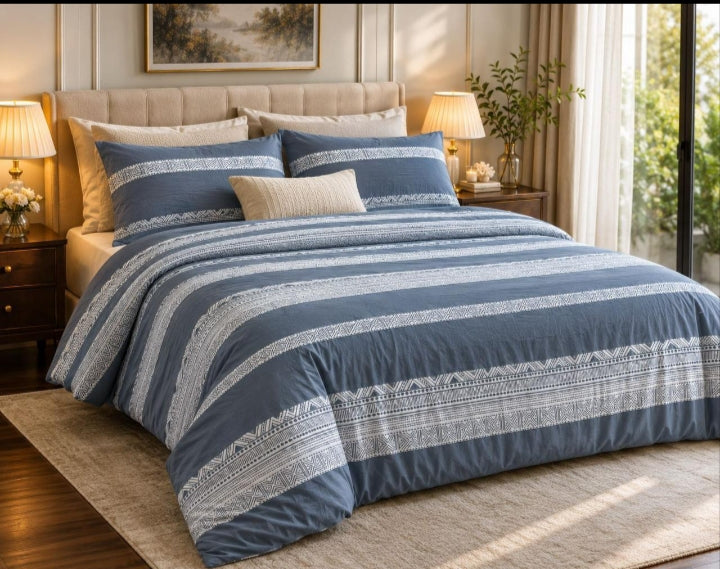 Blue Aztec Stripe 7 Piece Comforter Set with white geometric Aztec embroidery bands alternating with solid blue stripes styled on a luxury bed