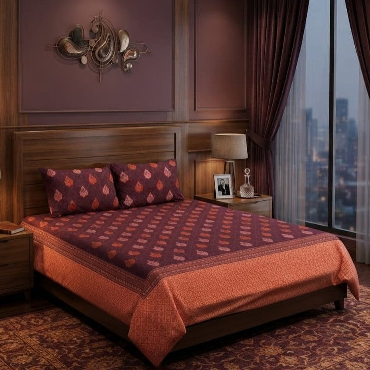Wine Tulip Bedsheet Set with deep wine-plum base featuring coral-pink tulip boteh motifs and ornate copper-orange paisley border styled on a luxury bed