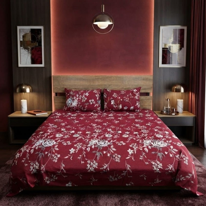 Burgundy Floral Vine Bedsheet Set with trailing silver-grey rose vines and white blossoms on deep burgundy maroon background styled on a luxury bed