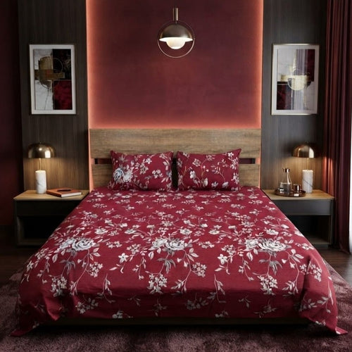 Burgundy Floral Vine Bedsheet Set with trailing silver-grey rose vines and white blossoms on deep burgundy maroon background styled on a luxury bed