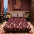 Wine Meadow Bedsheet Set with delicate pink wildflower stems and cosmos blooms on deep wine-plum background styled on a luxury bed