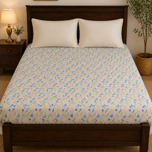 Blue Cornflower Bedsheet Set with scattered tiny blue cornflowers and yellow stems on white background styled on a luxury bed
