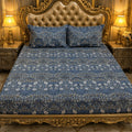 Navy Carnation Vine Bedsheet Set with dense William Morris-inspired trailing white carnation blooms and grey-green leaves on deep navy slate-blue background styled on a grand gold baroque luxury bed