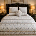 Ivory Snowflake Embroidery 7 Piece Comforter Set with white daisy snowflake blooms on diamond lattice quilted ivory background with grey medallion border styled on a grand dark carved baroque luxury bed
