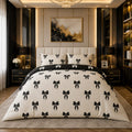 Black Bow Coquette 7 Piece Comforter Set with large black satin bows on cream ivory comforter and white bows on jet black flat sheet styled in a black gold luxury bedroom