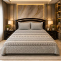 Grey Lattice Heritage Bedsheet Set with alternating bands of white hexagonal lattice Moroccan star motifs and charcoal tile on warm grey-taupe background styled in a marble-gold luxury bedroom