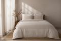 Cream Boho Tonal 7 Piece Comforter Set with ivory tonal embroidery bands featuring fringe tufts and floral motifs styled on a luxury bed